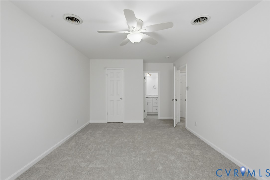 Neutral-toned carpeting, ceiling-mounted paddle fan with integrated lighting