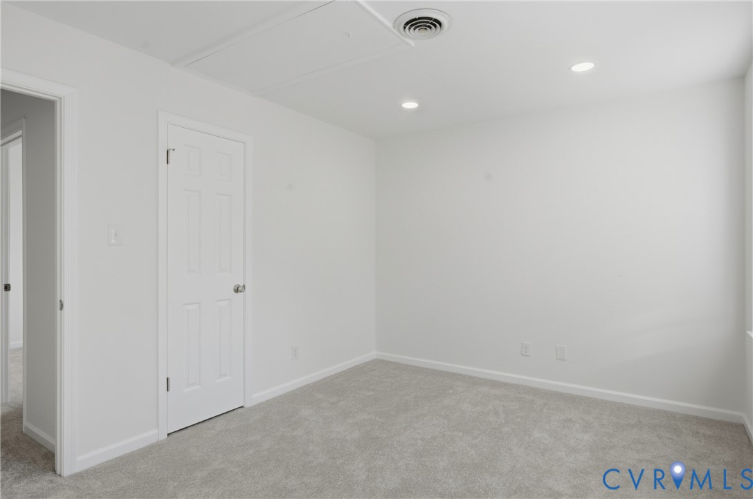 Neutral-toned interior space featuring wall-to-wall carpeting, and recessed ceiling lighting