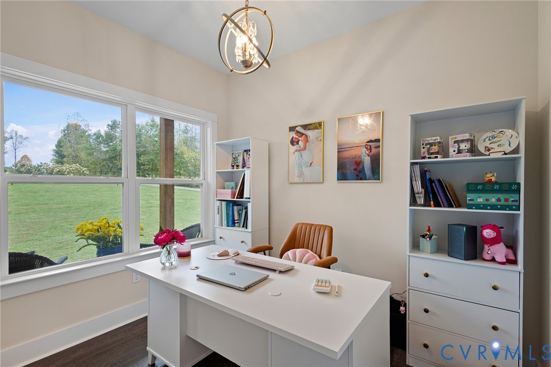 Room featuring wood-finish flooring, a large multi-pane window, and a spherical gold-tone metal pendant light fixture