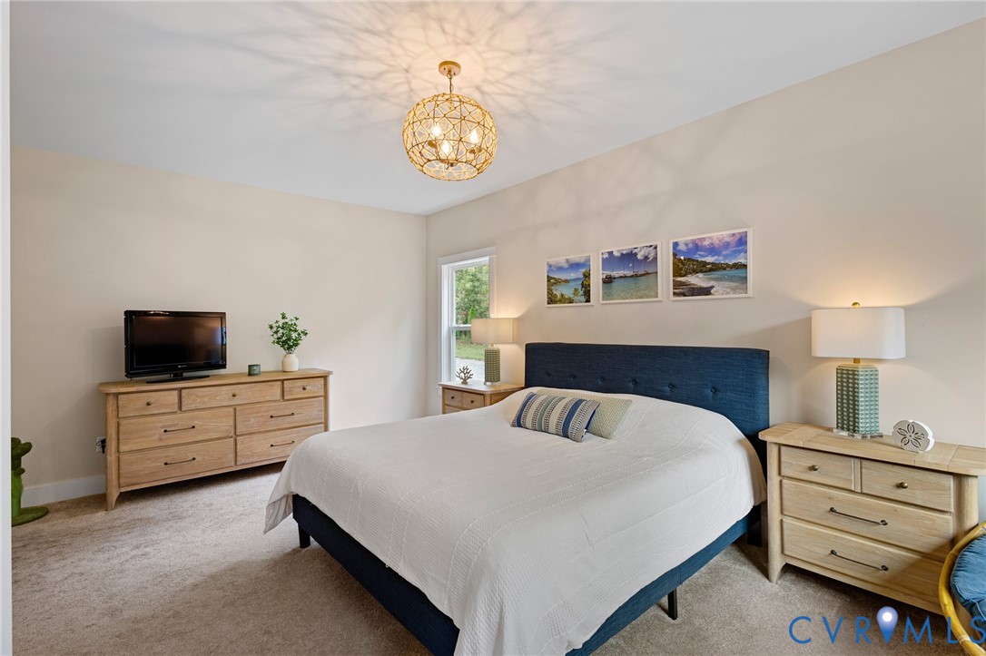 Neutral wall palette, carpeted flooring, and decorative spherical metal-frame ceiling lighting