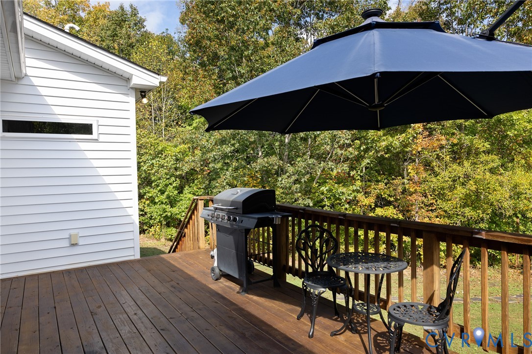 Elevated wood deck featuring a horizontal wood railing and white horizontal siding