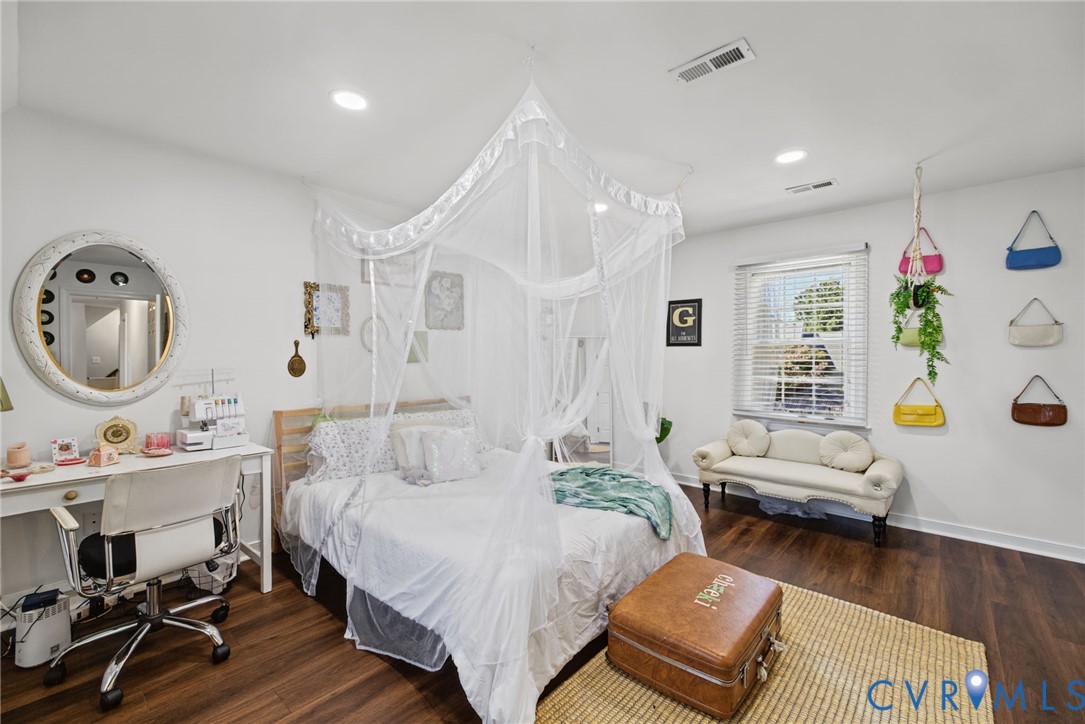 Bedroom featuring wood-finish flooring, recessed lighting, and a window with horizontal blinds