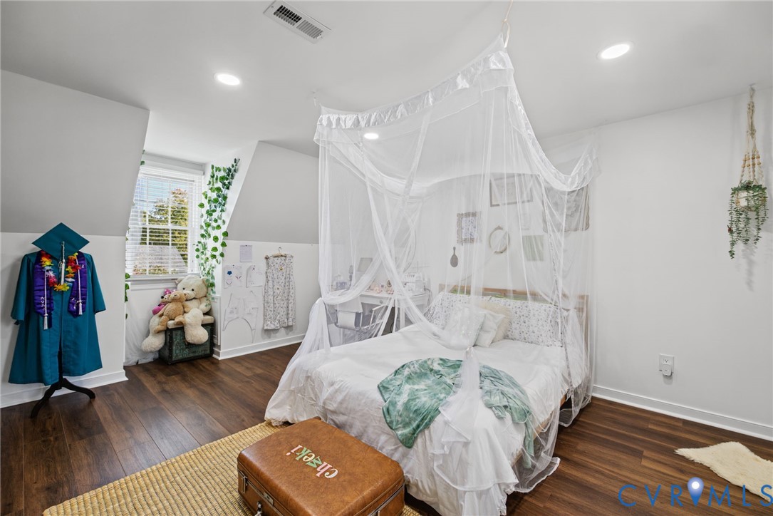 Room featuring wood-finish flooring, recessed lighting, and a multi-pane window with architectural wall angles