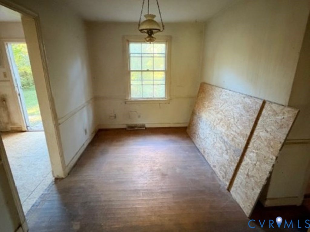 Hardwood flooring, wall-mounted pendant lighting, and multi-pane window with chair rail molding