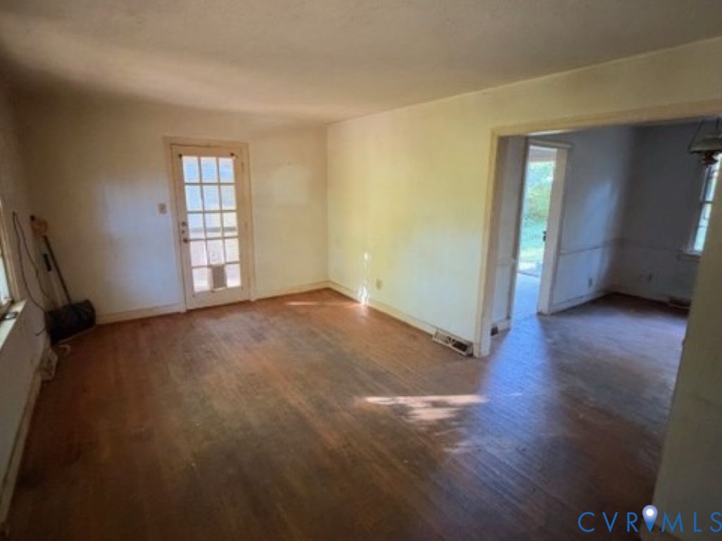 Wood-finish flooring, light-filled interior, and a nine-pane glass door leading to the exterior