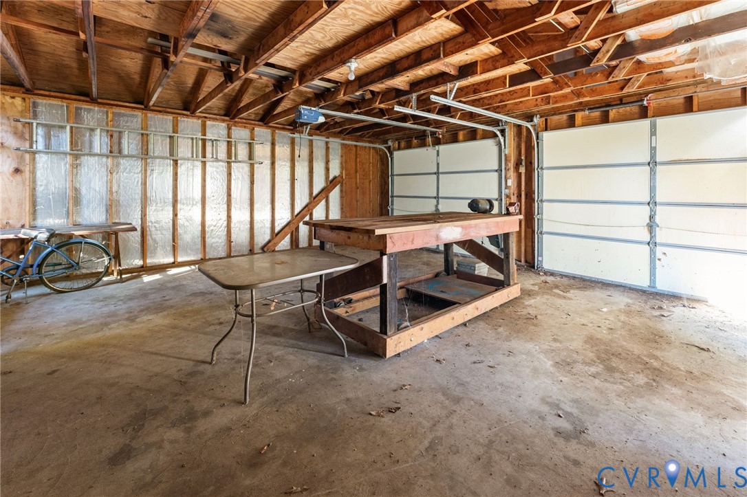 Two-car garage with concrete flooring and workbench.