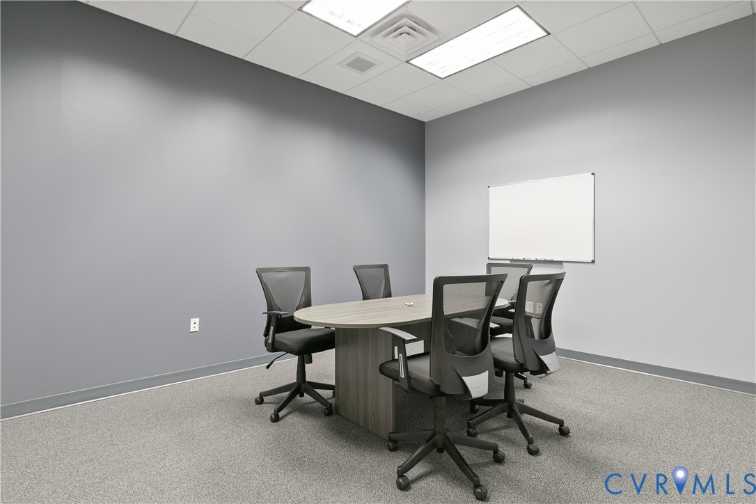 Meeting room featuring gray painted walls, a drop ceiling with recessed lighting, and a wall-mounted dry-erase board