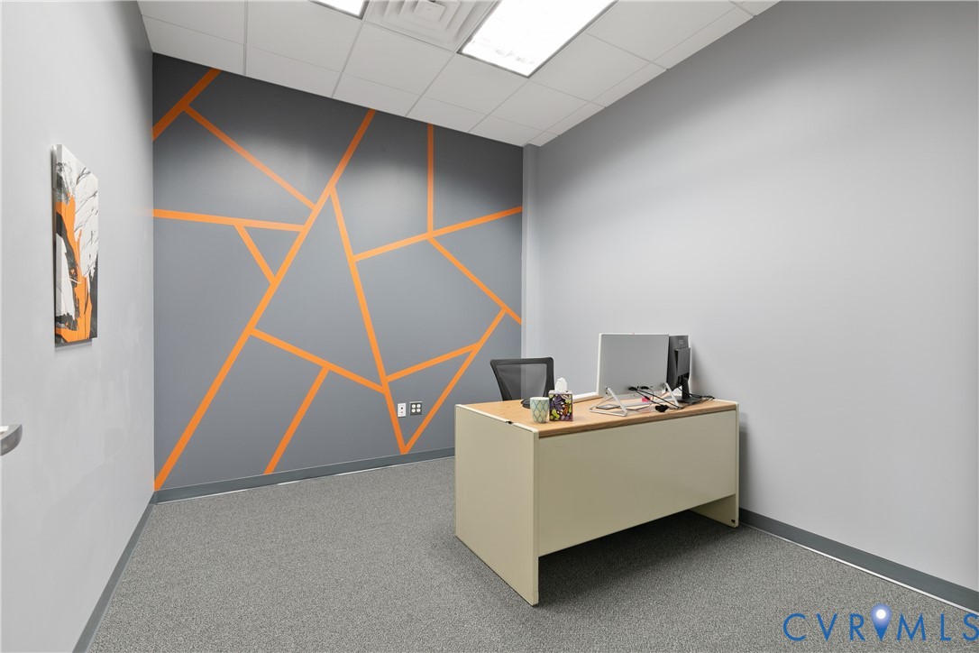 Interior space featuring neutral wall tones, a geometric-patterned accent wall, recessed lighting, and carpeting