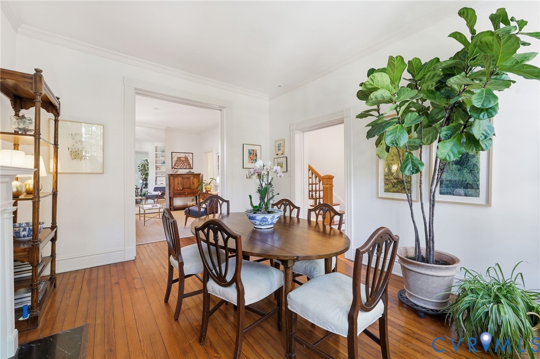 Dining area featuring hardwood flooring, crown molding, and an arched doorframe Dining area featuring hardwood flooring, crown molding, and an arched doorframe