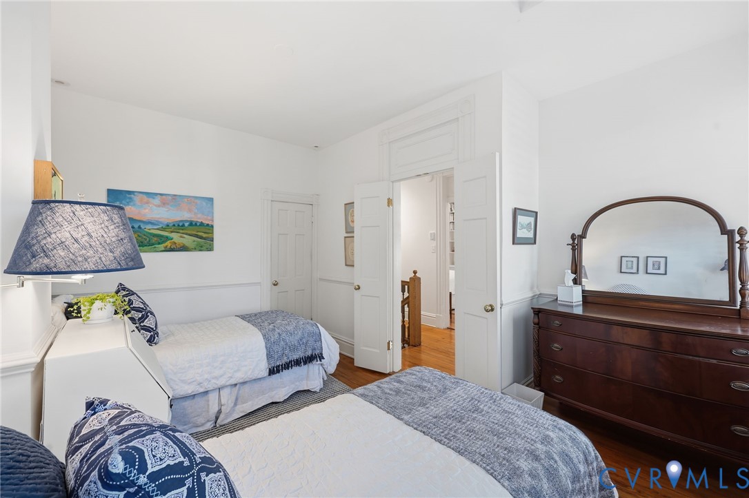 High ceilings with crown molding, wood-finish flooring, double-panel interior doors, and custom chair rail wainscoting