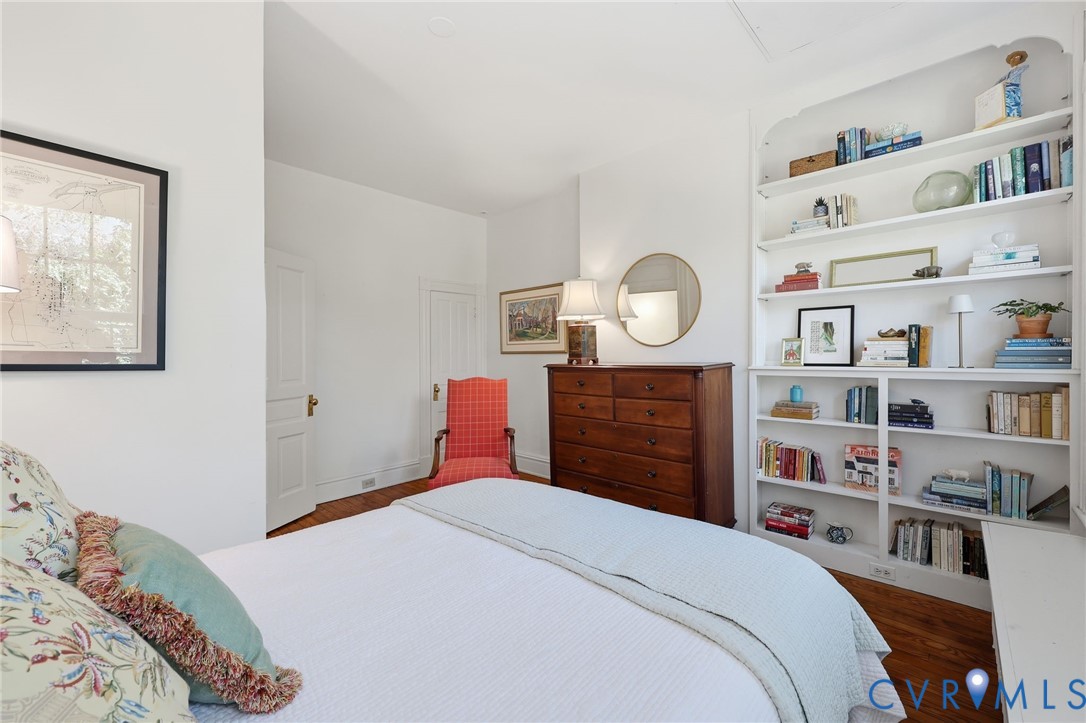Built-in white floor-to-ceiling shelving and wood-finish flooring
