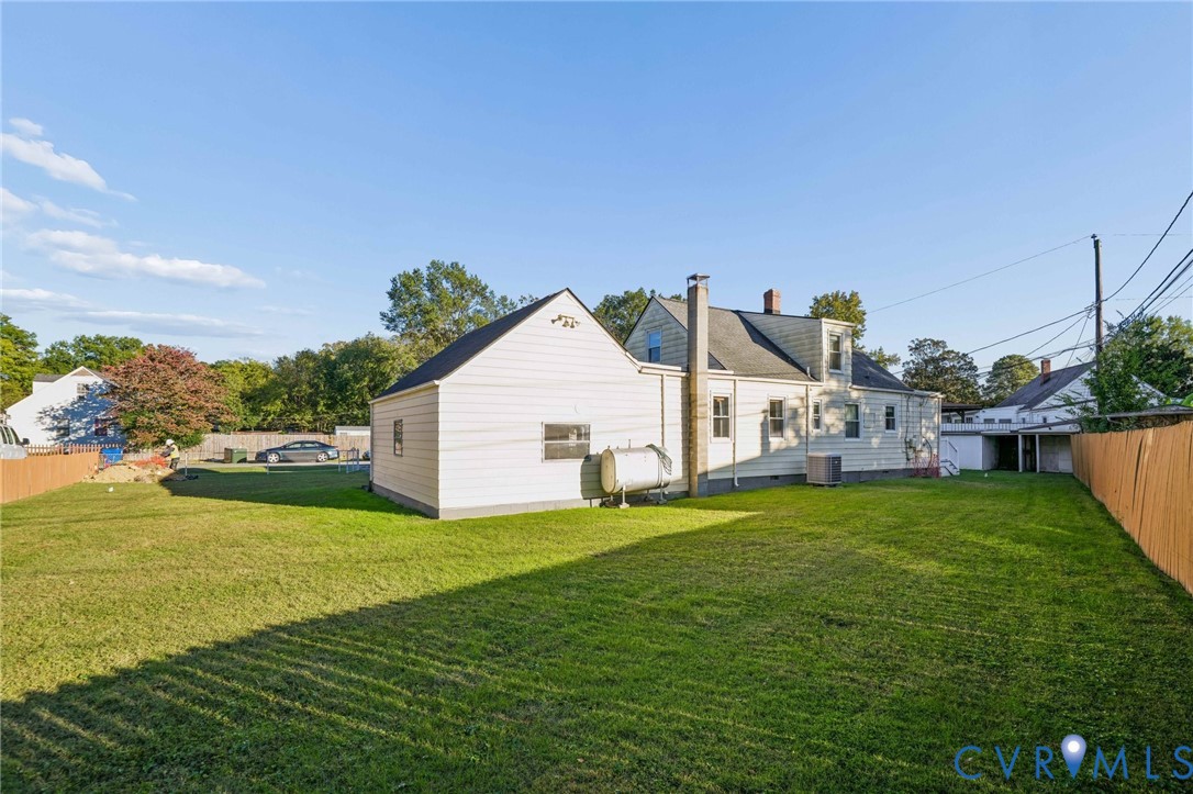 Expansive backyard featuring a manicured lawn, full-perimeter wood fencing