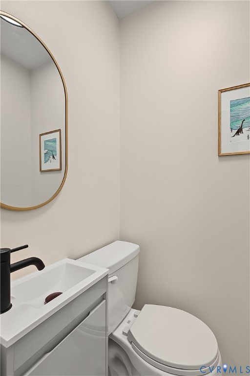 White vanity with integrated rectangular sink, matte black faucet, and oval wall-mounted mirror with gold finish
