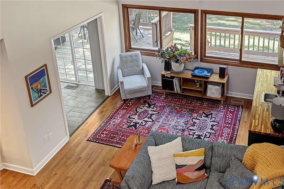Vaulted ceilings, wood-finish flooring, sliding glass patio doors, oversized horizontal windows, and a built-in butcher block countertop