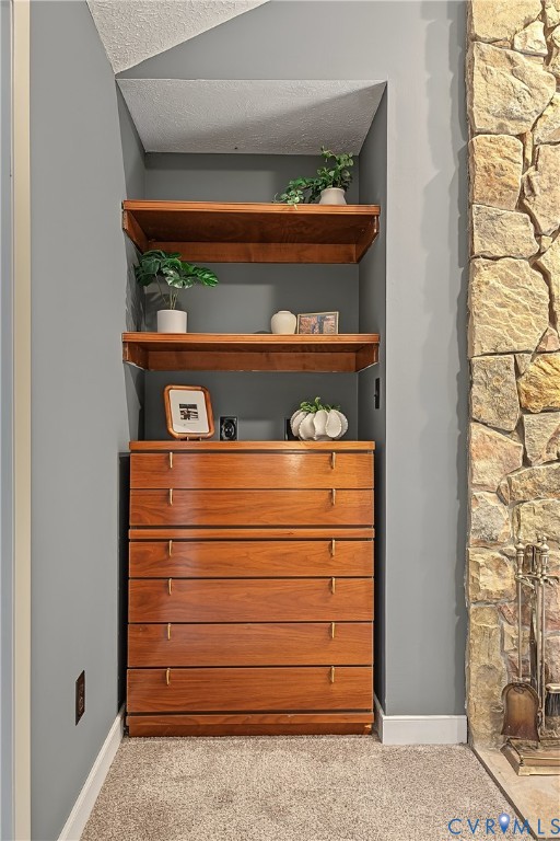Built-in wood cabinetry featuring a six-drawer dresser and dual open shelving, complemented by a floor-to-ceiling natural stone fireplace surround