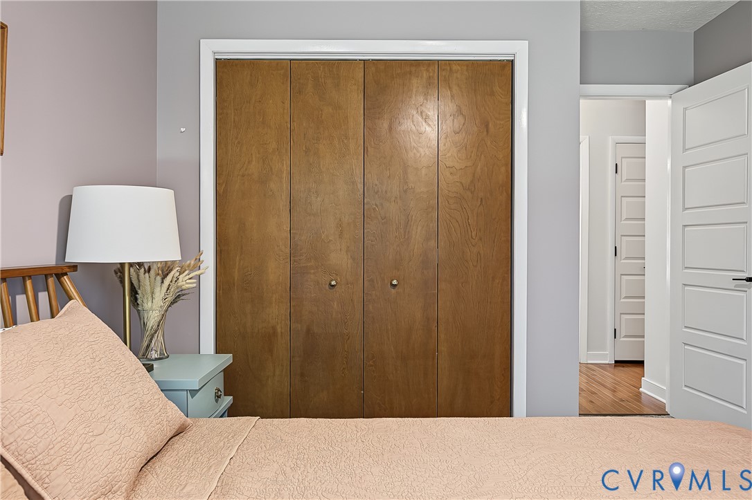 Bi-fold closet doors with wood-grain finish, white door casing, and five-panel interior door
