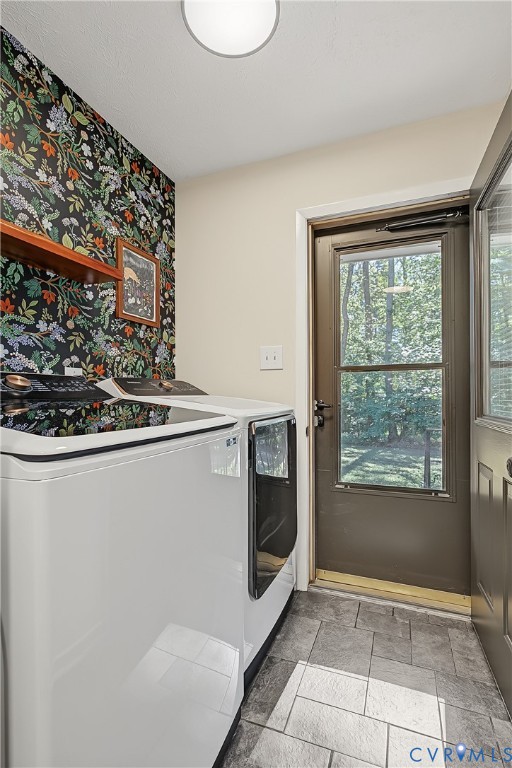 Utility space featuring patterned wallpaper, ceramic tile flooring, a wall-mounted wooden shelf, and a glass-paneled exterior door
