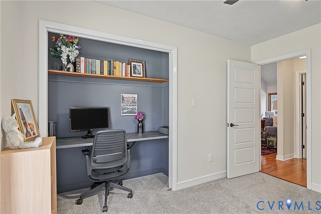 Built-in alcove featuring a desk surface, shelving, and neutral-tone wall finish, complemented by a five-panel interior door