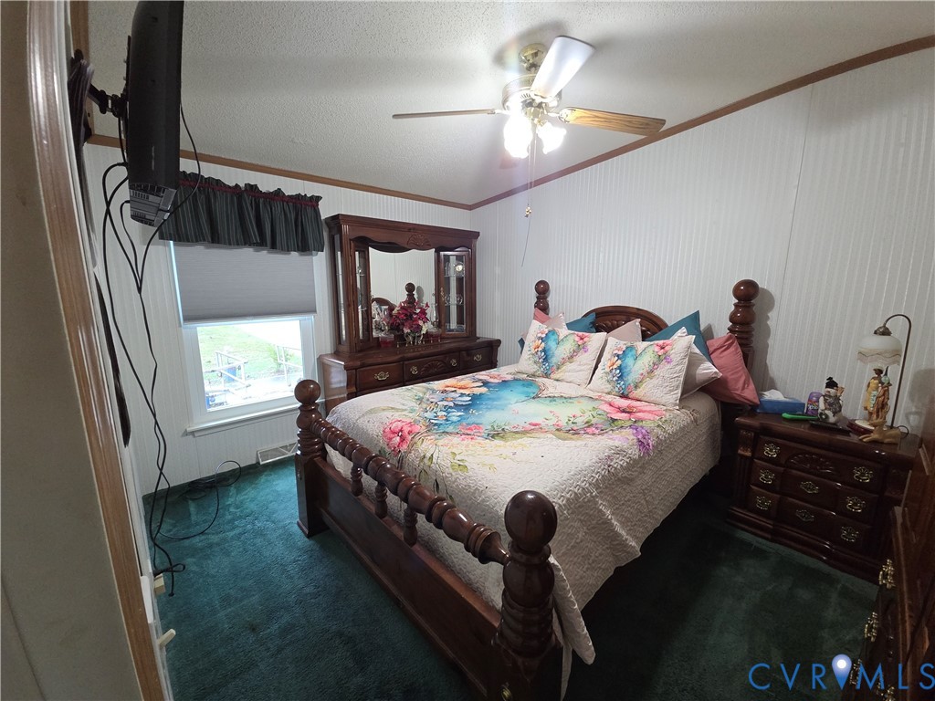 Room featuring vertical paneled walls, carpeted flooring, and a ceiling fan with integrated lighting
