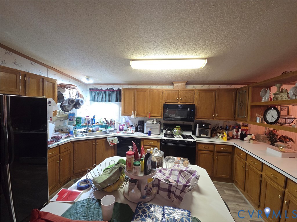 Kitchen featuring wood cabinetry, solid-surface countertops, built-in microwave, integrated range, and an island