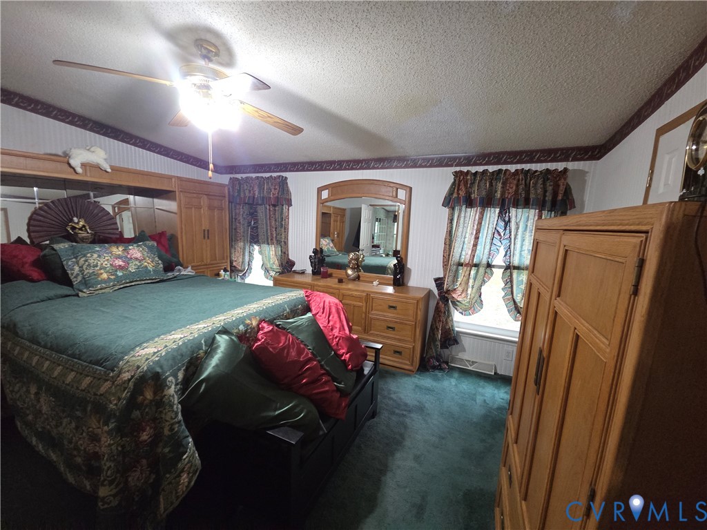 Built-in wood-finish cabinetry, arched wall-mounted mirror, and multi-blade ceiling fan