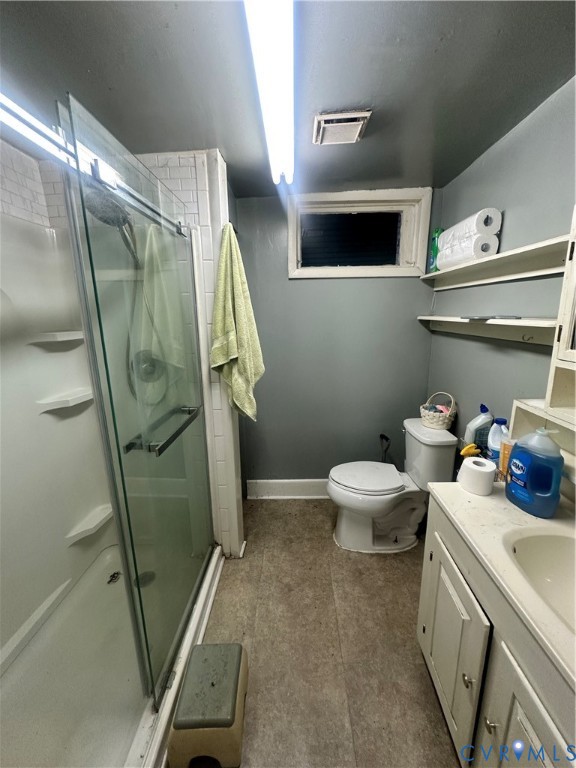 Bathroom featuring a shower stall with a glass door, built-in vanity cabinet, recessed basin, and wall-mounted shelving