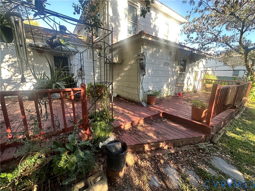 Multi-level wood deck featuring vertical wood railings and metal awning covers