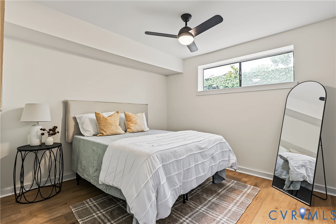 Wood-finish flooring, matte black ceiling fan with integrated lighting, and horizontal slider window