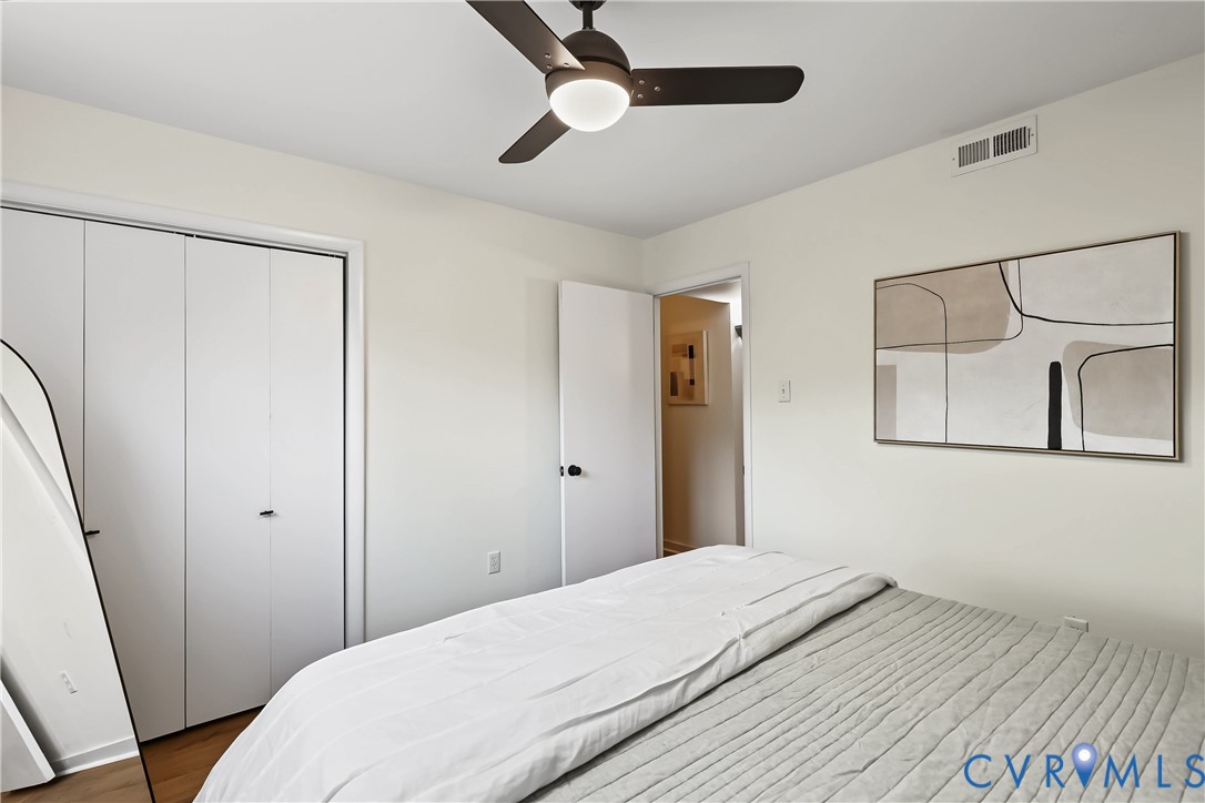 Room featuring neutral wall paint, wood-finish flooring, a ceiling fan with integrated lighting, and white bifold closet doors