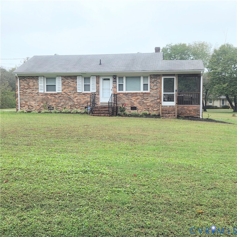 Single-story brick exterior featuring a shingled roof, front-facing screened porch, metal railings, and a wide lawn