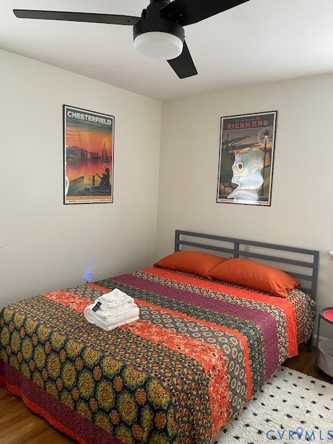 Room featuring wood-finish flooring and a matte black ceiling fan with integrated lighting