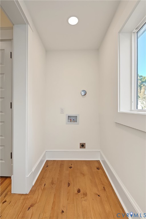 Utility area featuring wood-finish flooring, recessed ceiling lighting, a window, and hookups for appliances