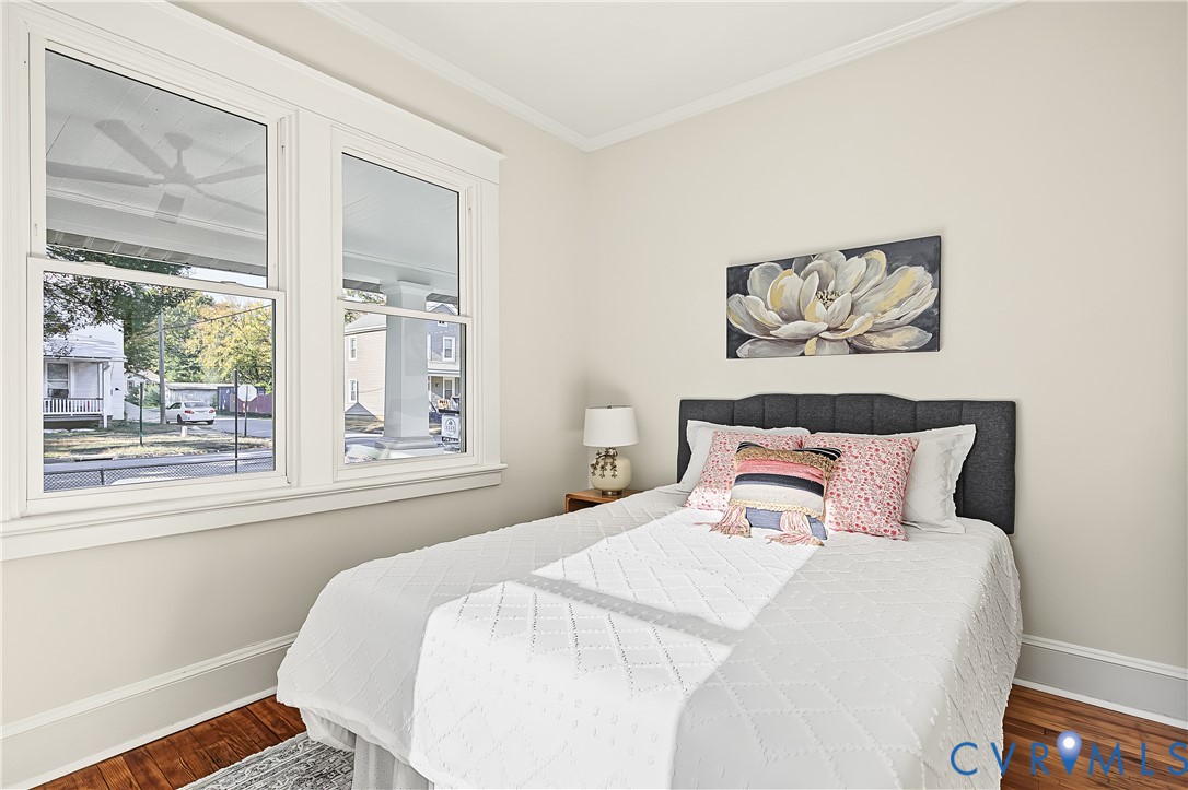 Double-hung windows with craftsman-style trim, wood-finish flooring, and crown molding