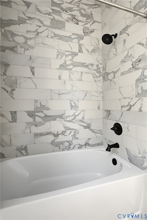 Full-height tub surround featuring rectified porcelain tile in a large-format running bond pattern, complemented by matte black hardware and a built-in soaking tub