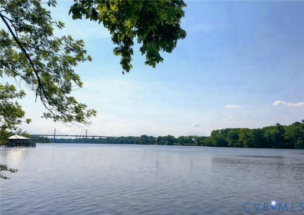 Waterfront property featuring a private covered dock, expansive water frontage, and mature canopy trees