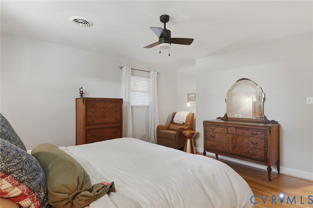 Neutral interior featuring wood-finish flooring, a matte black ceiling fan, and a single-window configuration