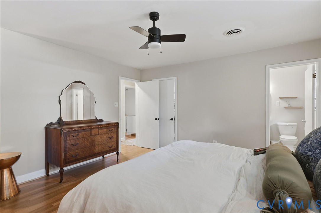 Room featuring wood-finish flooring, a matte black ceiling fan with integrated lighting, and neutral wall paint