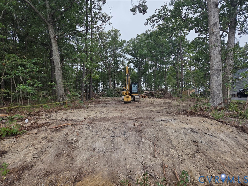 Clearing featuring mature trees, wooded perimeter, and leveled earth Clearing featuring mature trees, wooded perimeter, and leveled earth