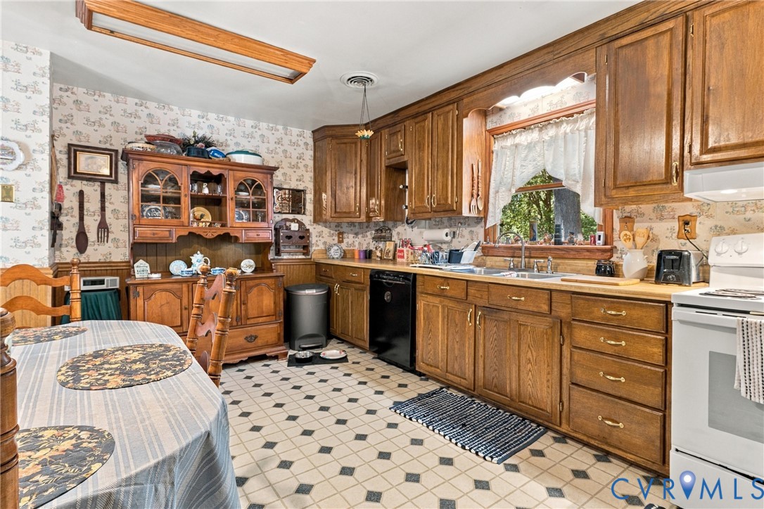 Kitchen featuring wood cabinetry, built-in hutch, tiled flooring, and window above the sink