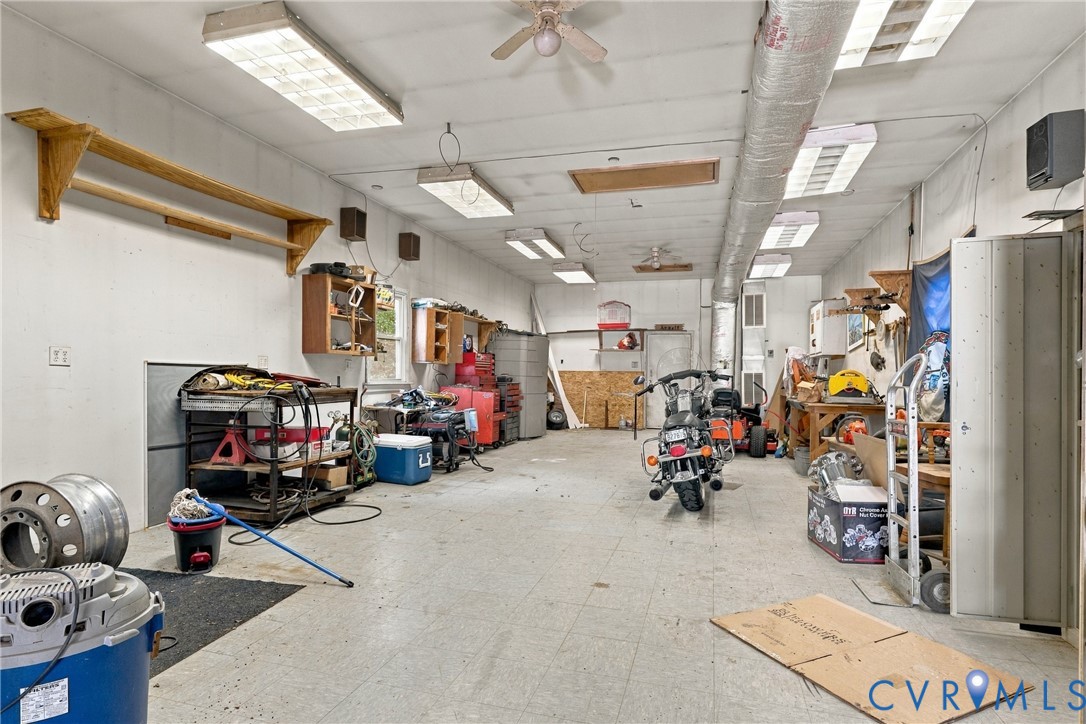 Multi-car garage featuring recessed lighting, ceiling-mounted fan, and integrated wall shelving