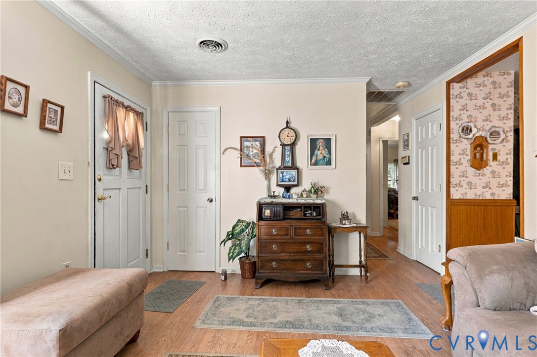 Interior entryway featuring light-toned wood-finish flooring, six-panel interior doors, and a decorative wainscot paneled partition