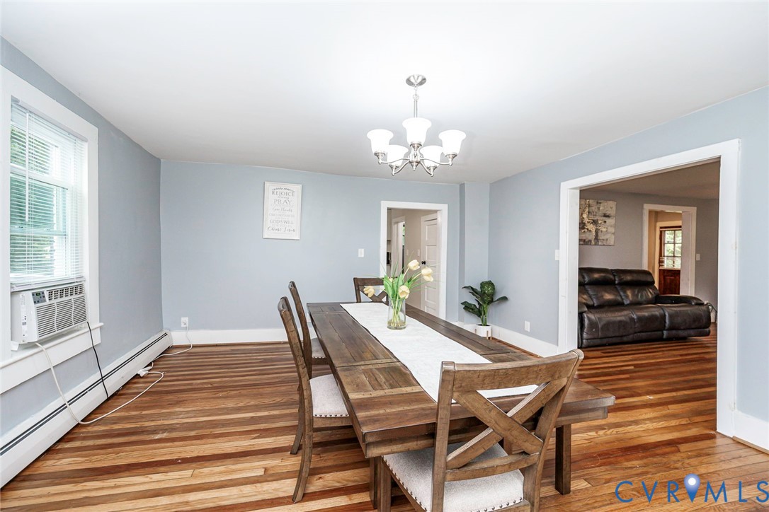 Hardwood flooring, five-light candelabra chandelier, and traditional window trim Hardwood flooring, five-light candelabra chandelier, and traditional window trim