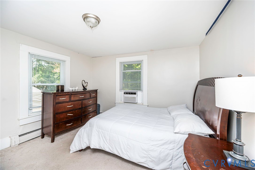 Room featuring neutral-toned walls, dual windows with white trim, and a flush-mount ceiling fixture