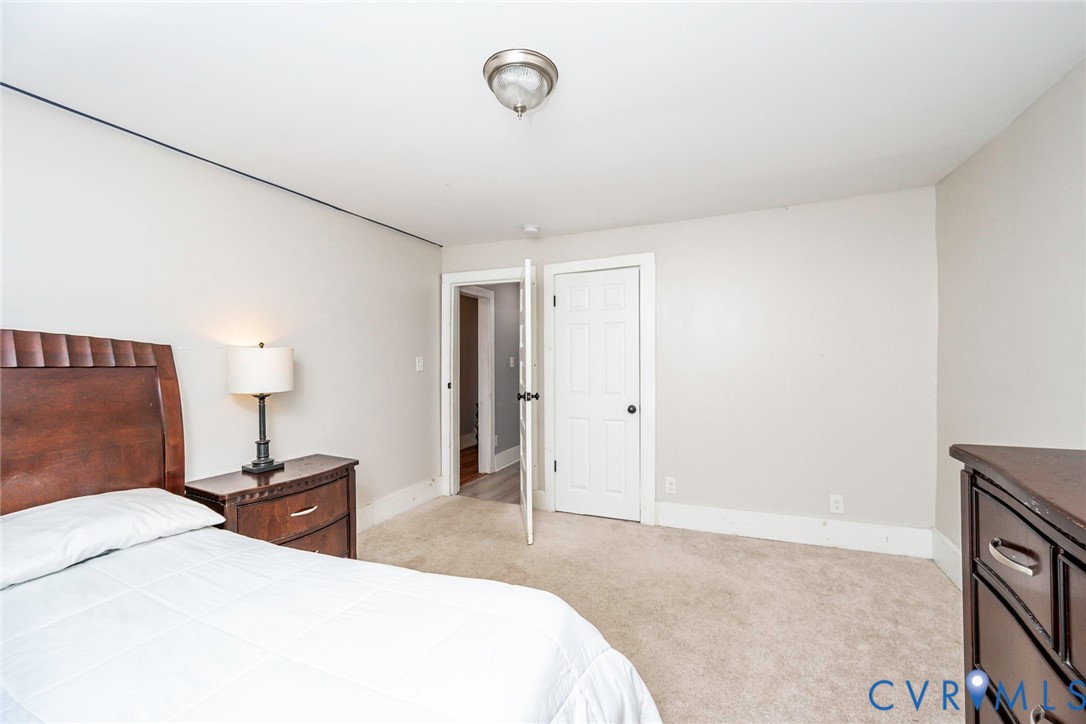Neutral wall tones, carpeted flooring, and a six-panel interior door