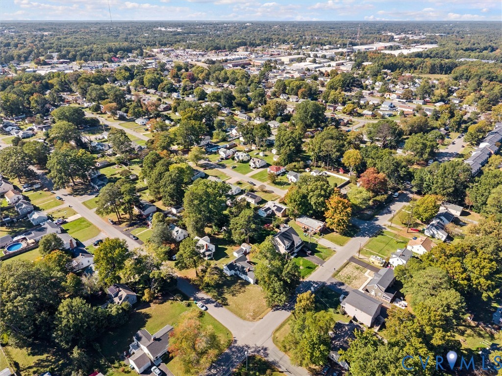 Aerial perspective featuring established residential streets with mature tree canopy and surrounding wooded areas