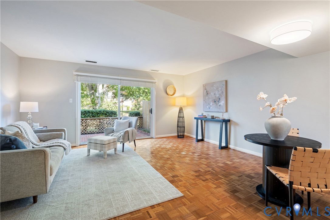Parquet wood-finish flooring, sliding glass door, flush-mount ceiling lighting, and exterior lattice fencing