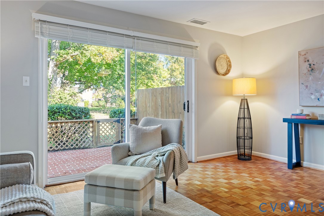 Sliding glass door featuring horizontal blinds and parquet wood flooring