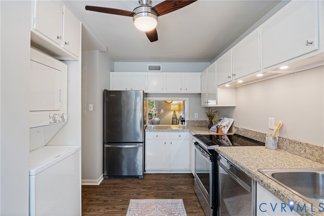 Kitchen featuring white cabinetry, stone-finish countertops, stainless steel appliances, wood-finish flooring, and a ceiling fan