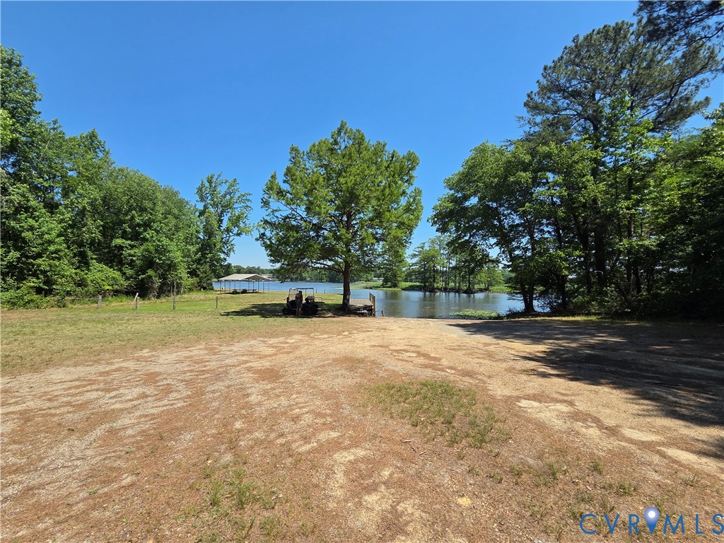 Waterfront lot featuring a natural shoreline, mature trees, open grounds, and a private boat slip