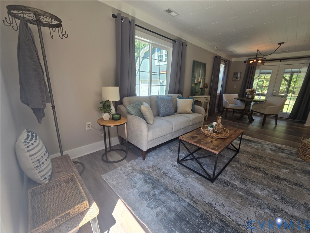 Wood-finish flooring, grid-pattern windows, multi-pane glass door, and a textured ceiling finish